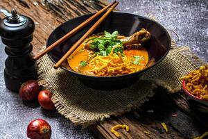 khao então eu receita khao Soi, Khao então eu kai, tailandês Macarrão khao então eu, frango Curry com tempero em de madeira chão, norte tailandês Comida conceito. lanna Comida foto