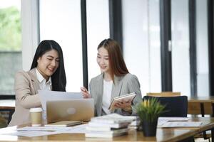 dois o negócio mulheres estão discutindo a trabalhos elas ter feito juntos e trocando Ideias. para trabalhos para desenvolve a o negócio melhorar. foto