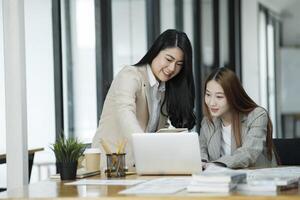 dois o negócio mulheres estão discutindo a trabalhos elas ter feito juntos e trocando Ideias. para trabalhos para desenvolve a o negócio melhorar. foto