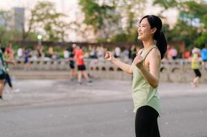 fêmea corredor. em forma jovem ásia mulher com verde roupa de esporte aeróbica dança exercício dentro parque e desfrutando uma saudável ar livre. ginástica corredor menina dentro público parque. bem estar ser conceito foto