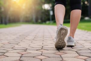 corredor mulher. fechar acima pessoa Treinamento esporte corredor jovem fêmea sapato em andar caminho dentro público parque. ginástica perna e pé exercício atleta. maratona dentro natureza. ativo saudável estilo de vida exercite-se conceito. foto