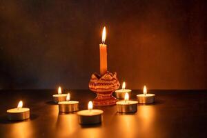 muitos velas aceso contra uma Preto fundo.queima velas em Sombrio memória de mesa foto