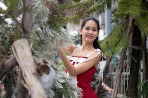 retrato do Adolescência menina dentro uma vermelho vestir relaxado e sorridente dentro uma Nevado quintal. foto