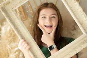 retrato do Adolescência menina com suspensórios dentro cenário quadro, Armação foto