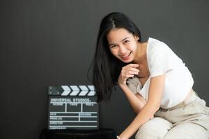 retrato do ásia jovem mulher dentro em branco branco camiseta em Preto fundo foto