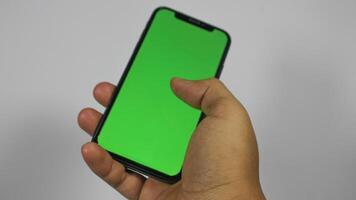 mão segurando inteligente telefone com verde tela. isolado em branco fundo foto