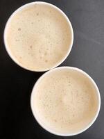 dois copos do café. dois papel óculos com café em uma Preto fundo foto