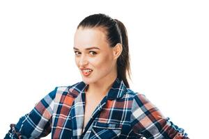 uma à moda mulher poses para uma cenário. uma mulher dentro uma xadrez camisa posando para uma cenário foto