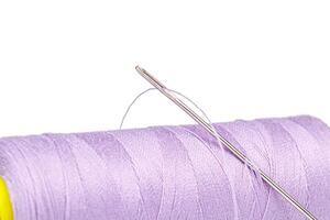 macro meada do fio roxa cores com uma agulha em uma branco fundo foto