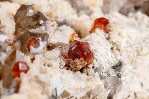 macro mineral pedra espessartina, feldspato, esfumaçado quartzo, em uma branco fundo foto