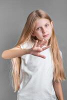 uma pequeno menina mostrando uma placa do protesto ou recusa com dela mão. foto