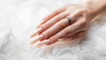 mão do uma jovem mulher com branco pérola manicure foto