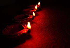 happy diwali - lâmpadas diya acesas durante a celebração do diwali. Lanternas coloridas e decoradas são iluminadas à noite nesta ocasião com rangoli de flores, doces e presentes. foto