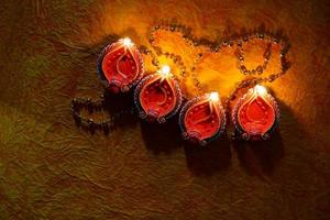 happy diwali - lâmpadas diya acesas durante a celebração do diwali. Lanternas coloridas e decoradas são iluminadas à noite nesta ocasião com rangoli de flores, doces e presentes. foto