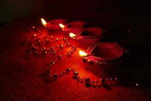 happy diwali - lâmpadas diya acesas durante a celebração do diwali. Lanternas coloridas e decoradas são iluminadas à noite nesta ocasião com rangoli de flores, doces e presentes. foto