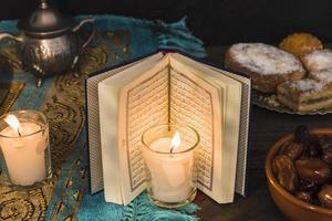 livro árabe de velas perto de sobremesas foto
