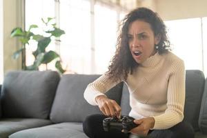 mulher laitin jogando videogame com as mãos segurando um joystick foto