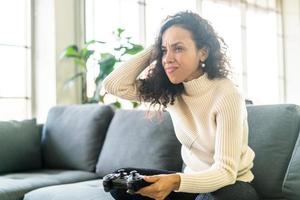 mulher laitin jogando videogame com as mãos segurando um joystick foto