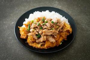 Carne de porco frita com alho e ovo coberto com arroz foto