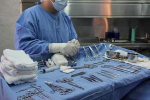 enfermeira instrumentista preparando os instrumentos médicos para a operação. foto