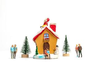 pessoas em miniatura comemorando o natal em casa foto