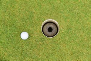 buraco de golfe e bola de golfe na grama verde do campo de golfe foto