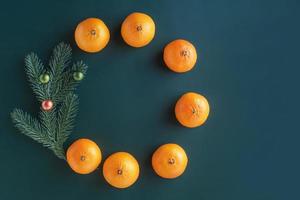 composição de Natal em um fundo verde. árvore de Natal com brinquedos e tangerinas frescas. foto