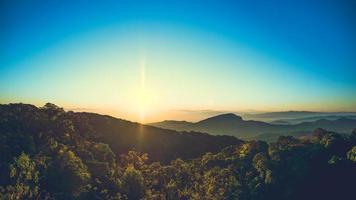 picos de montanha em paisagem de nevoeiro, colina de montanha, nascer do sol, céu, nuvens foto