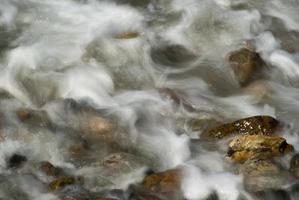 ondas suaves em uma praia rochosa pela manhã foto