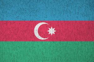 bandeira do azerbaijão retratada em cores de tinta brilhantes na parede de reboco em relevo antigo. banner texturizado em fundo áspero foto