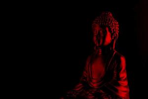 Buda purnima e vesak dia conceito, vermelho Buda estátua com baixo chave luz contra profundo Preto fundo foto