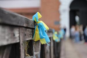 fitas dentro a cores do a nacional bandeira do Ucrânia estão amarrado para a corrimão foto