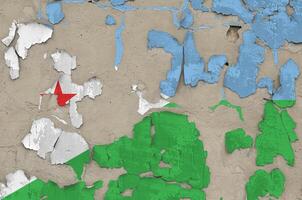 djibouti bandeira retratado dentro pintura cores em velho obsoleto bagunçado concreto parede fechar-se. texturizado bandeira em rude fundo foto