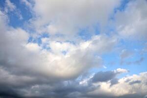 lindo nuvem formações dentro a céu com luz solar atrás. branco nuvens em dramático azul céu foto