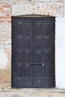 muito velho sólido porta dentro tijolo pedra parede do castelo ou fortaleza do 18º século foto