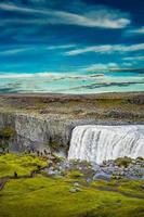 vista sobre a maior e mais poderosa cachoeira da europa chamada dettifoss na islândia, perto do lago myvatn, no céu azul, verão foto