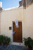 véu de noiva em uma porta como um sinal de que uma mulher que mora naquela casa comemora seu casamento naquele dia. cidade velha de rhodes, grécia foto