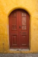 paredes coloridas e porta de madeira na cidade velha de Rodes, Grécia foto