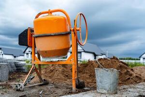 a laranja concreto misturador Onde cimento é preparado para construção trabalho carrinhos em a rua foto