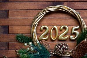feliz Novo ano dourado números 2025 em acolhedor festivo Castanho de madeira fundo com lantejoulas, neve, luzes do guirlandas. saudações, cartão postal. calendário, cobrir foto