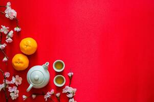 chá conjunto com laranjas e pêssego Flor em vermelho pano fundo para chinês Novo ano conceito. foto