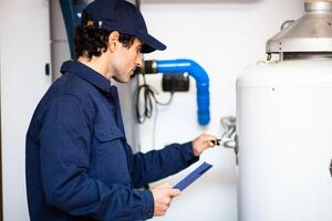 sorridente técnico reparação a água quente aquecedor foto