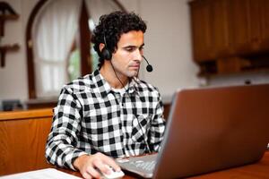 cara usando fone de ouvido e computador portátil computador, teletrabalho conceito foto