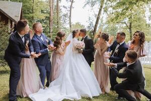 comprimento total retrato do a recém-casados e seus amigos às a casamento. a noiva e noivo com damas de honra e amigos do a noivo estão tendo Diversão e alegria às a casamento. foto