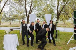 alegre, jovem, enérgico testemunhas do a noivo Próximo para a noivo. amigos felicitar a noivo. noivo e dele engraçado amigos tendo Diversão em a Casamento dia do a recém-casados. foto