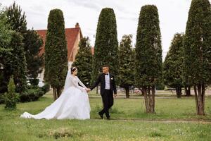 retrato do uma jovem noiva e noivo caminhando dentro uma lindo parque depois de a Casamento cerimônia, frente visualizar. feliz Casamento casal, cópia de espaço foto