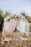 casamento. Casamento cerimônia. arca. a arco decorado com Rosa e branco flores carrinhos dentro a pátio, dentro a área do a Casamento cerimônia foto