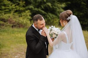 ela contado ele sim. uma jovem homem Beijos dele da esposa mão com uma ouro anel, propondo casado. noivado do uma jovem casal dentro amar. conceito do amor e unidade. foto