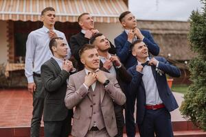 alegre, jovem, enérgico testemunhas do a noivo Próximo para a noivo. amigos felicitar a noivo. noivo e dele engraçado amigos tendo Diversão em a Casamento dia do a recém-casados. foto