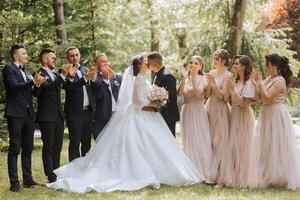 comprimento total retrato do a recém-casados e seus amigos às a casamento. a noiva e noivo com damas de honra e amigos do a noivo estão tendo Diversão e alegria às a casamento. foto